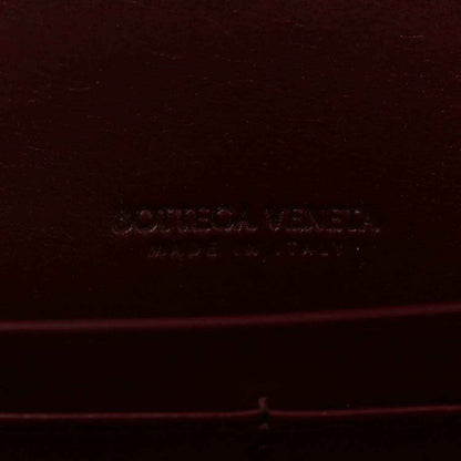Burgundy leather clutch bag with embossed Bottega Veneta logo stamp