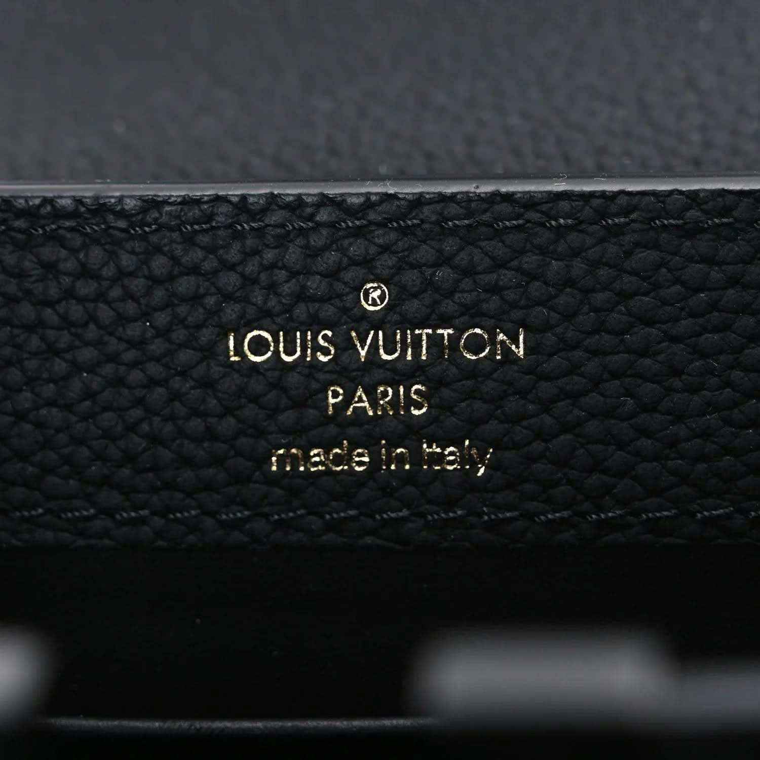 Louis Vuitton PARIS made in Italy stamp on black leather handbag.