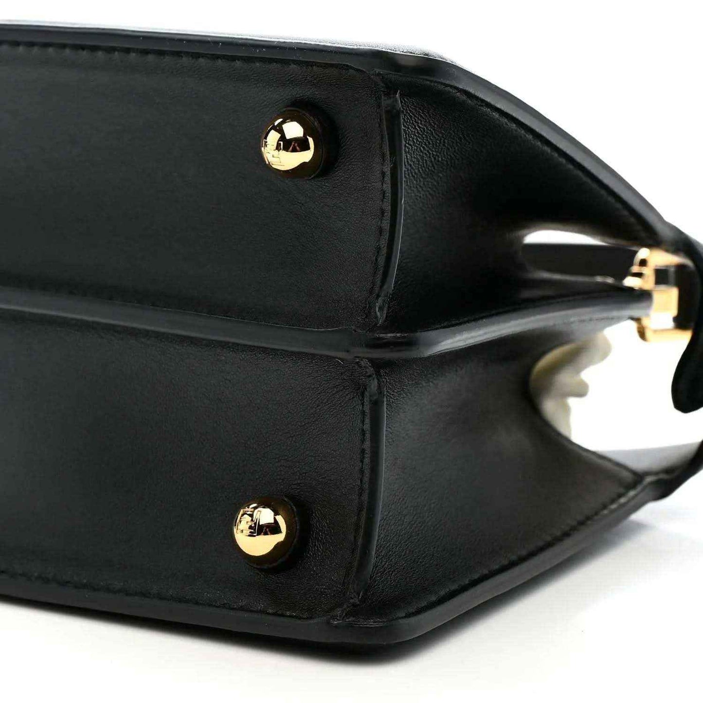 Black leather satchel side with gold-toned snap button and strap ring