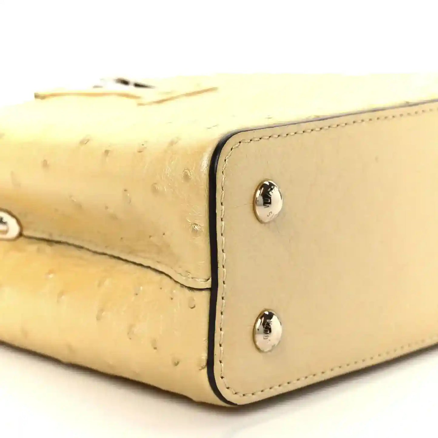 Yellow mini bag corner detail with two silver snaps and curved seam