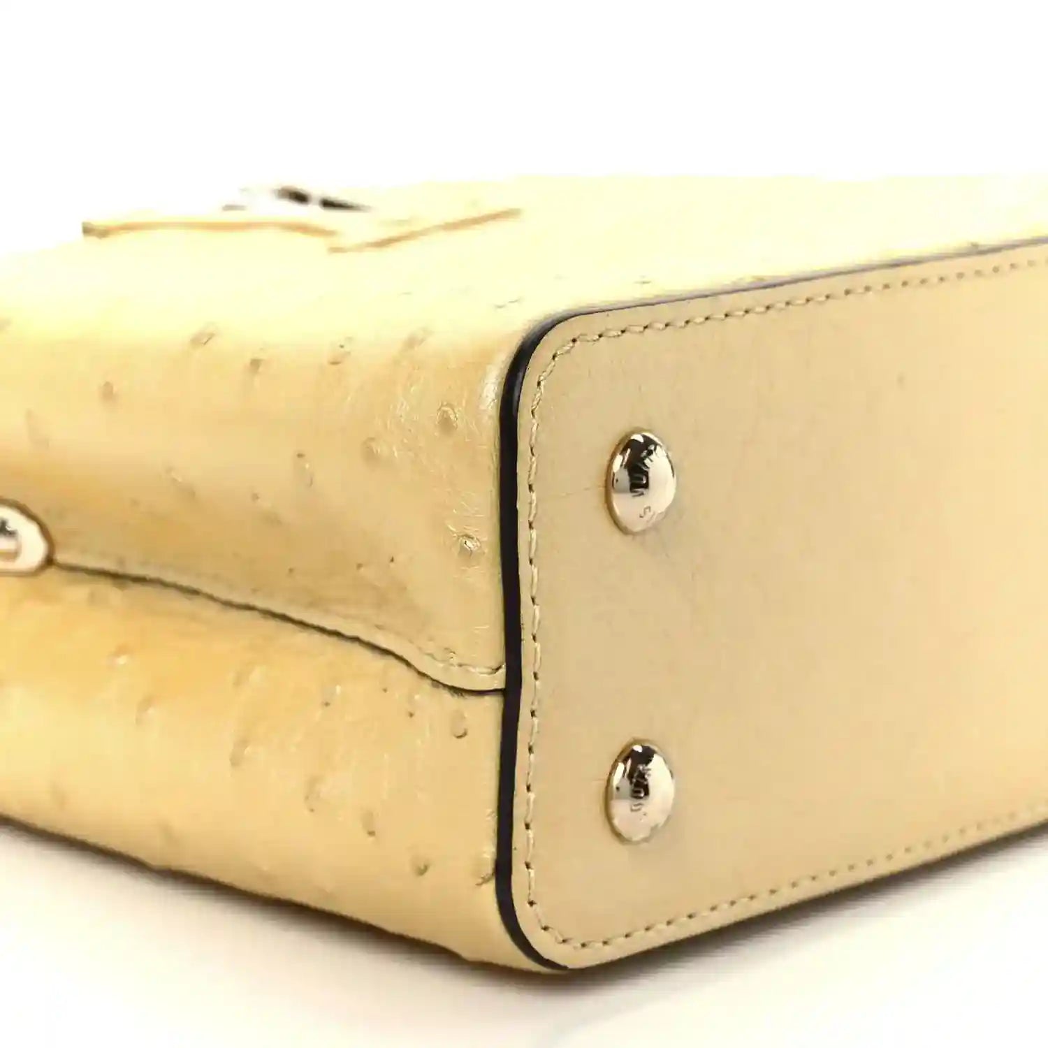 Yellow mini bag corner detail with two silver snaps and curved seam