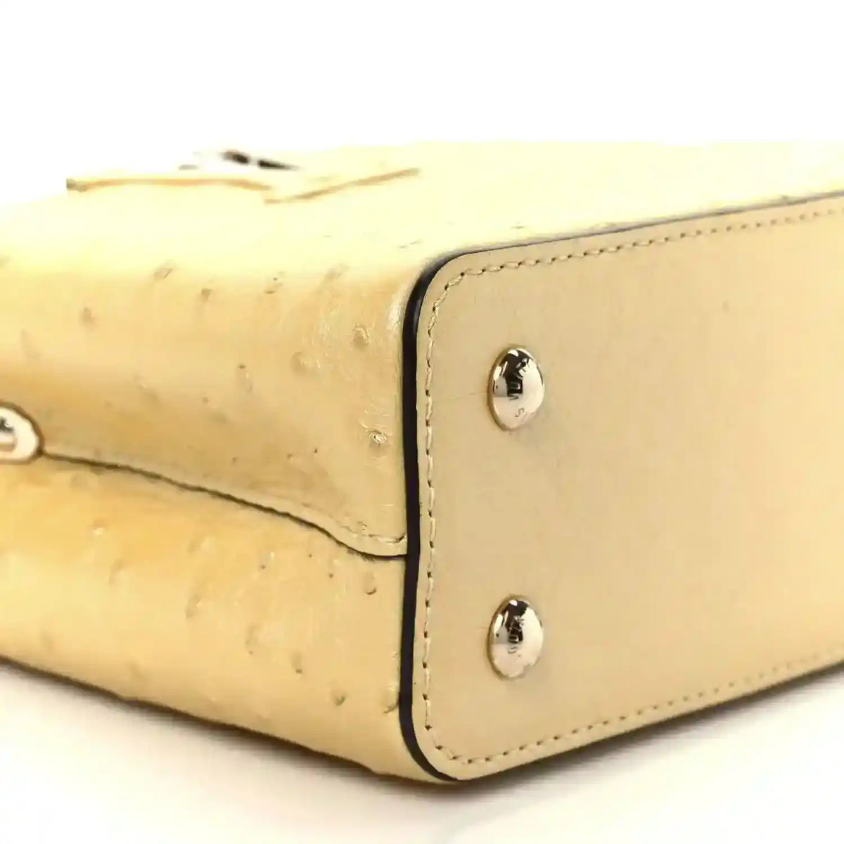Yellow mini bag corner detail with two silver snaps and curved seam