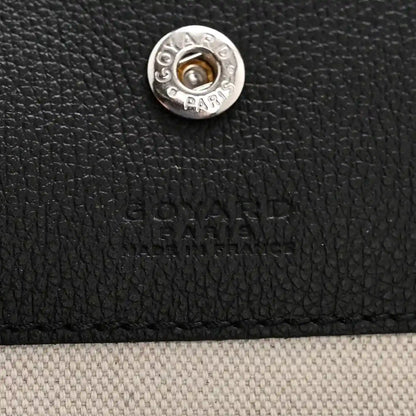 Goyard hobo bag front snap button with silver-tone hardware on black textured canvas
