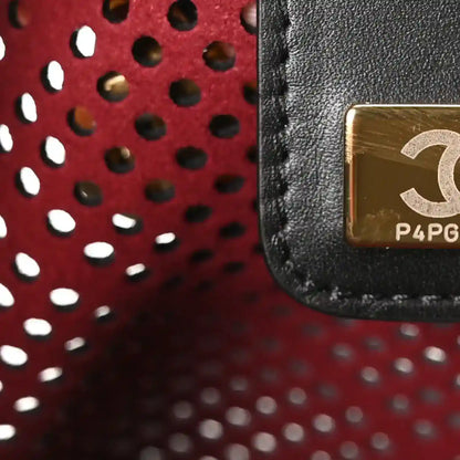 Small black perforated handbag with CC logo plaque and red interior lining