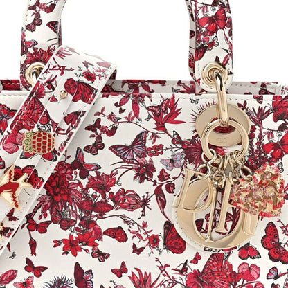 White and red floral handbag front with gold-tone Dior charm and ring handle