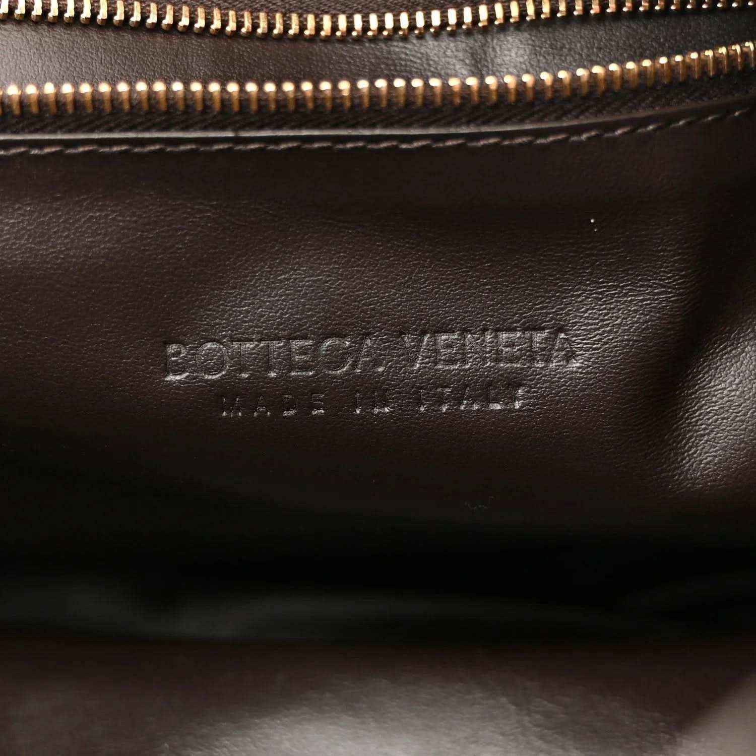 Leather interior close-up with gold-tone zipper and stamped branding