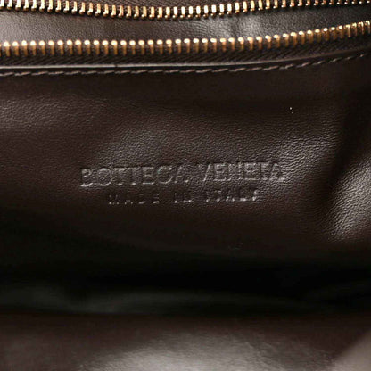 Leather interior close-up with gold-tone zipper and stamped branding