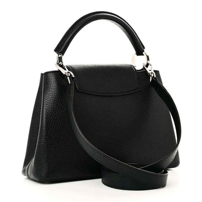 Black leather handbag with flap front, top handle, and crossbody strap
