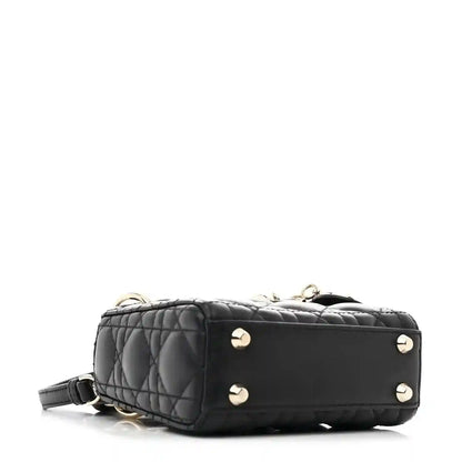 Black quilted micro handbag with gold-tone stud accents and short shoulder strap