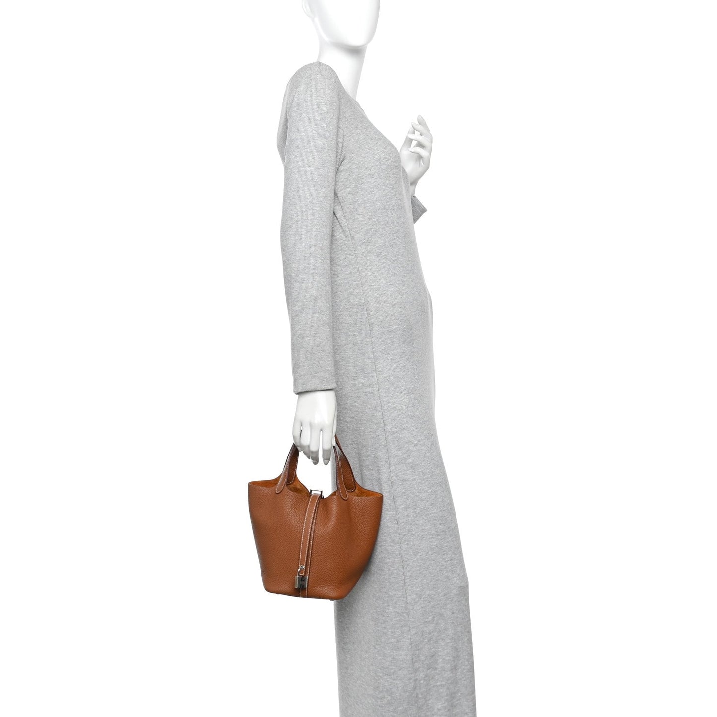 Brown leather bucket tote bag with short handles, carried at side