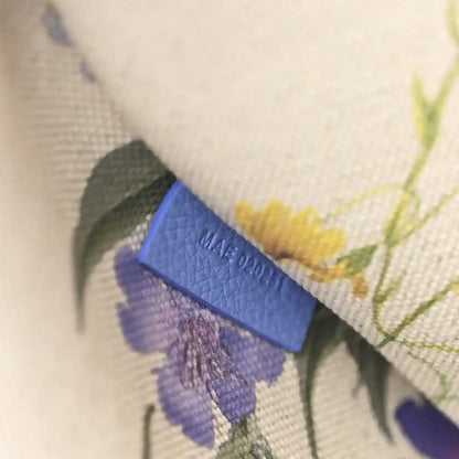 Close-up of Goyardine Villette PM tote bag tag on floral-pattern interior lining