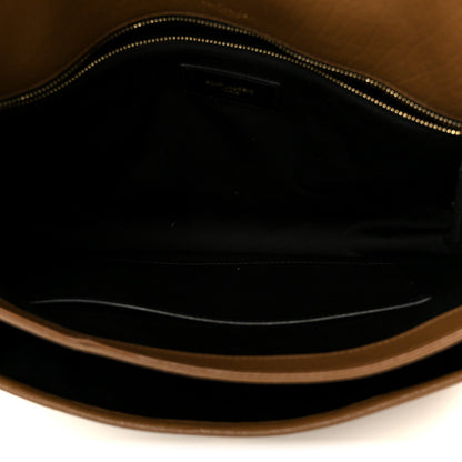 Satchel interior with zippered opening and dark lining, grained leather trim.