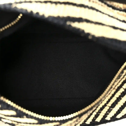 Small raffia puzzle bag interior view with black lining and natural striped trim