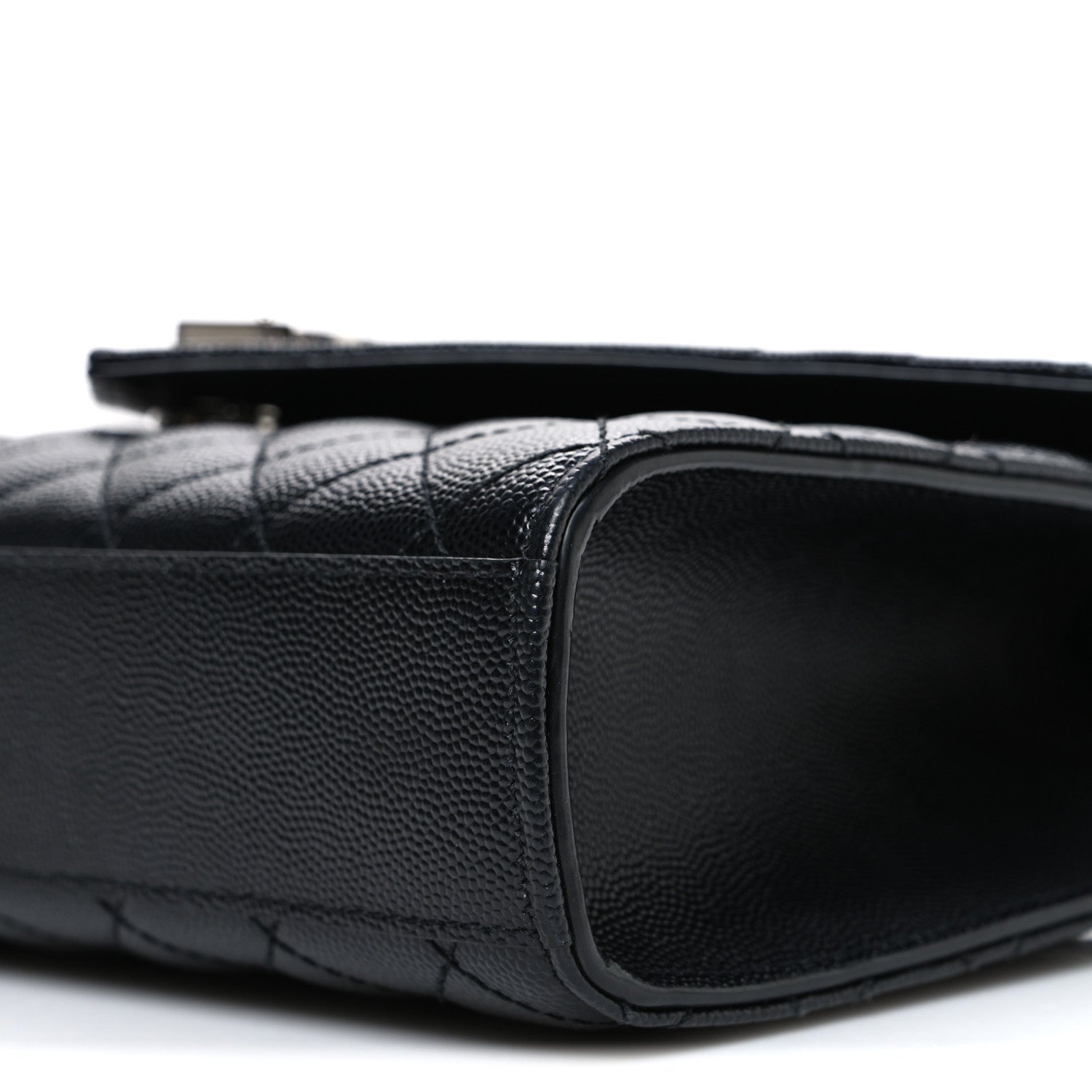 Black quilted leather satchel side edge with rounded corner and smooth border