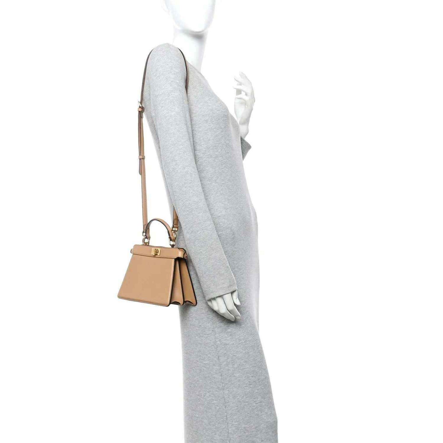 Tan mini satchel worn on shoulder with short strap and gold-tone hardware