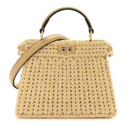 Petite raffia satchel bag with tan leather handles and gold-tone front clasp detail.