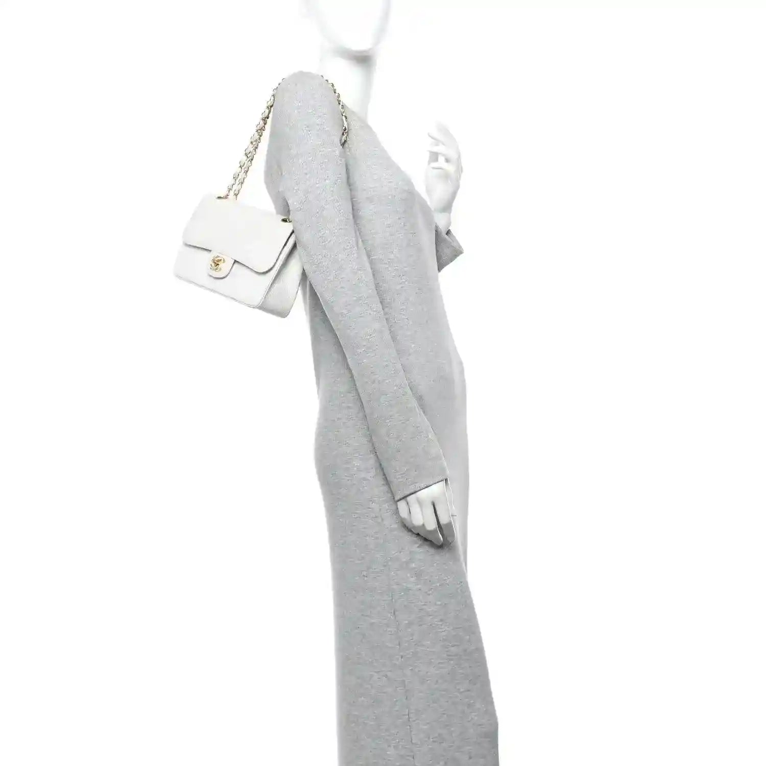 White leather mini shoulder bag with gold chain strap and flap, worn crossbody