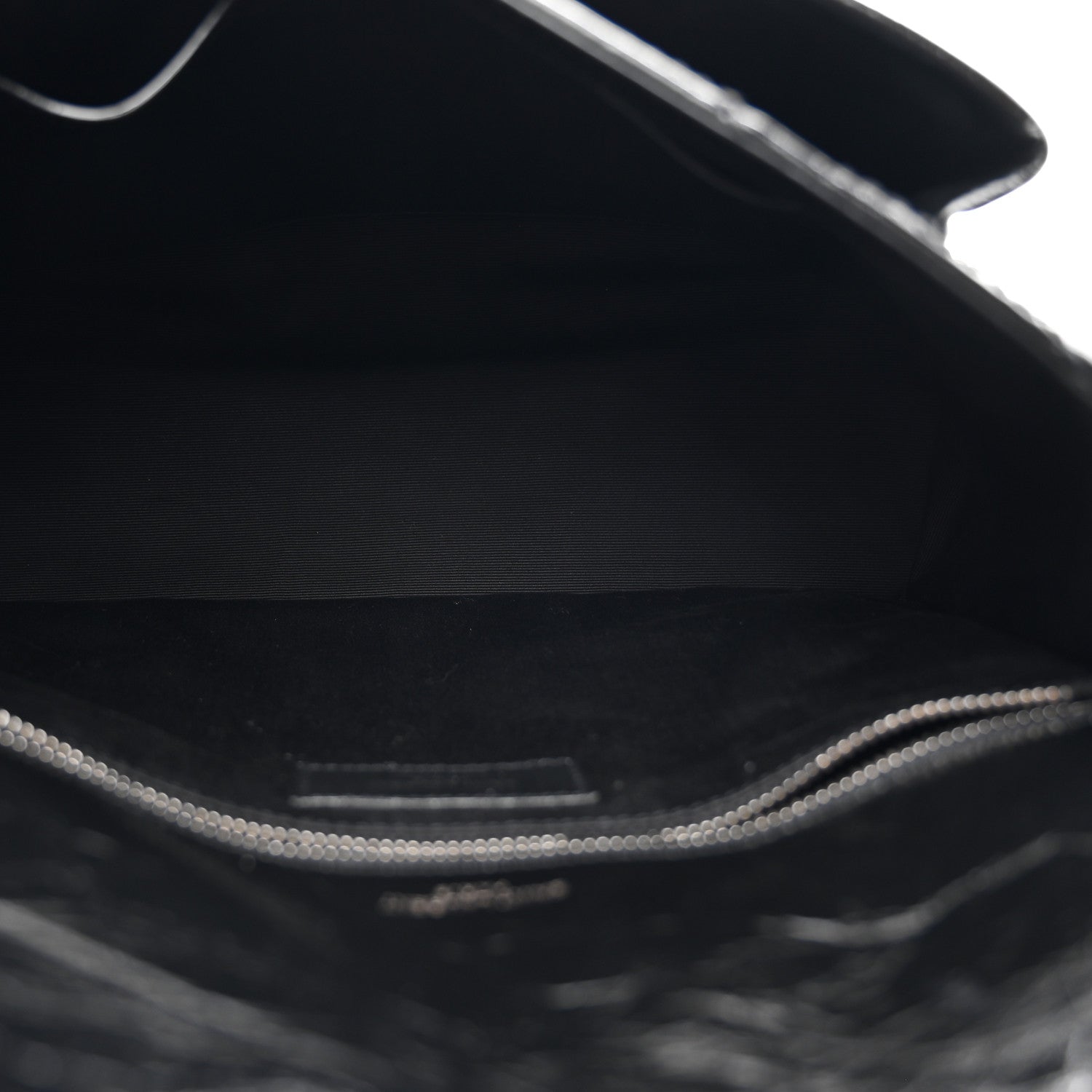 Black satchel interior lining with visible top edge and metal chain hardware