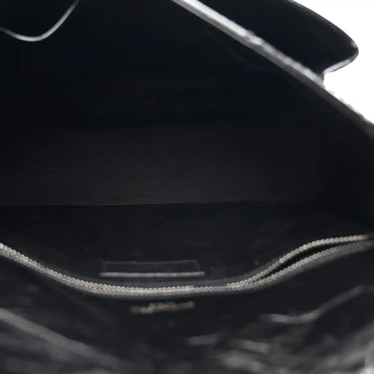 Black satchel interior lining with visible top edge and metal chain hardware