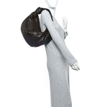 Small intrecciato leather Jodie bag held over shoulder, woven hobo silhouette