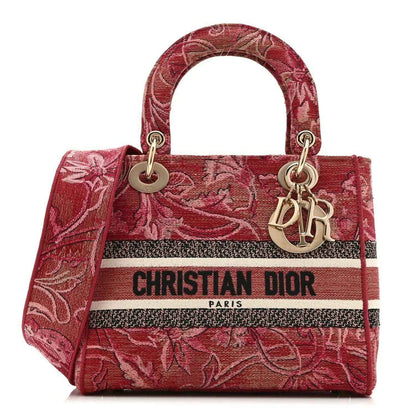 Pink embroidered canvas medium handbag with top handles, gold rings, and logo stripe
