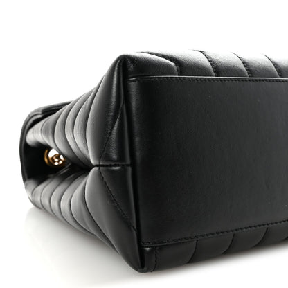 Black quilted satchel corner with stacked chevron stitching.