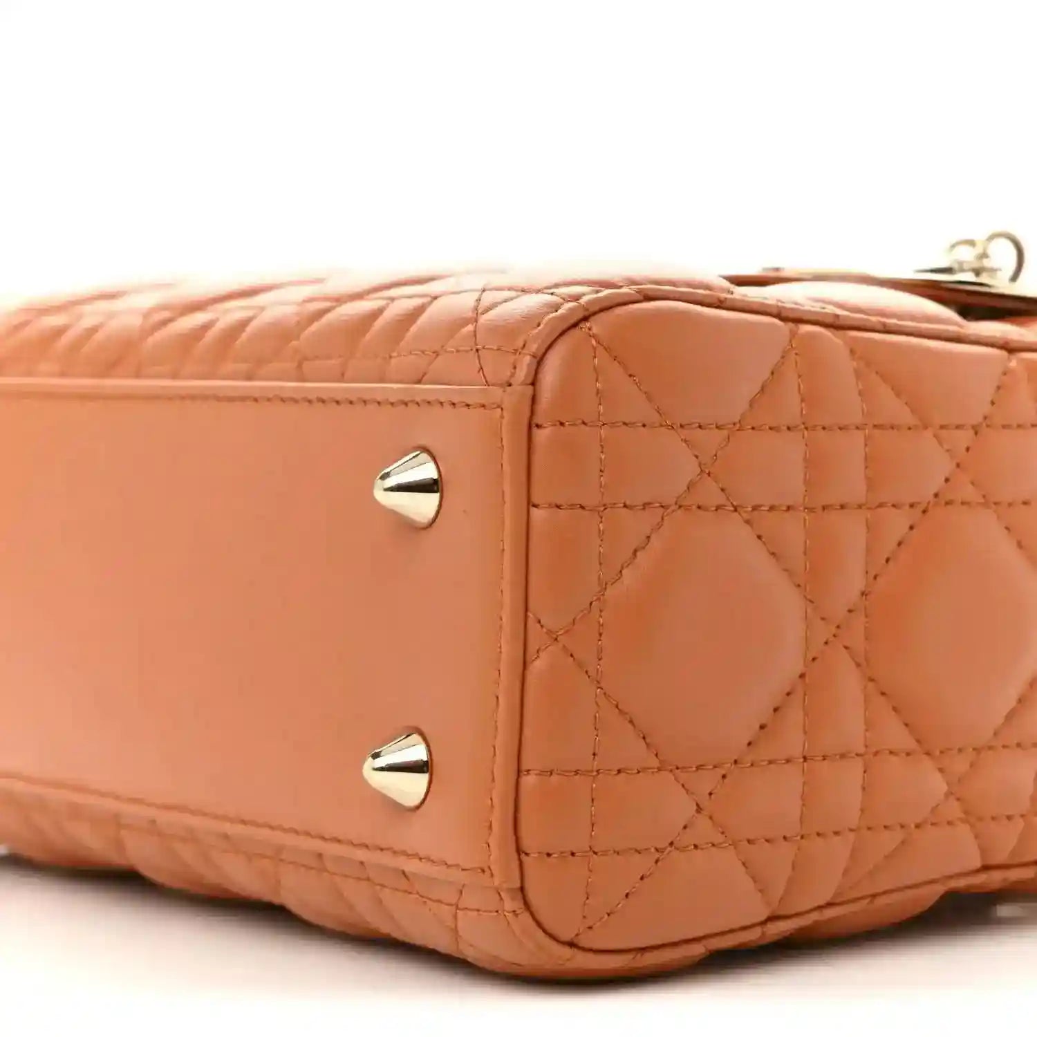 Front side close-up of orange quilted Lady Dior tote with two gold snap studs