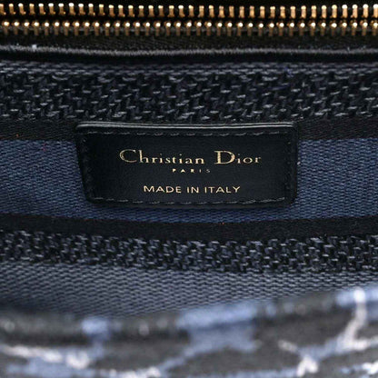 Christian Dior canvas handbag with leather logo tag reading “Christian Dior”