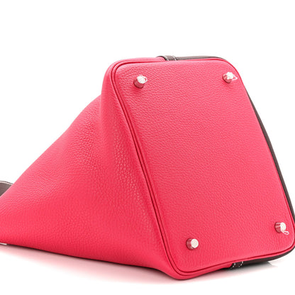Bright red bucket bag with dark brown trim and silver-tone corner studs