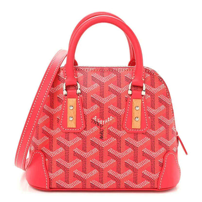 Fuchsia mini handbag with red patterned body, leather handles, and silver hardware