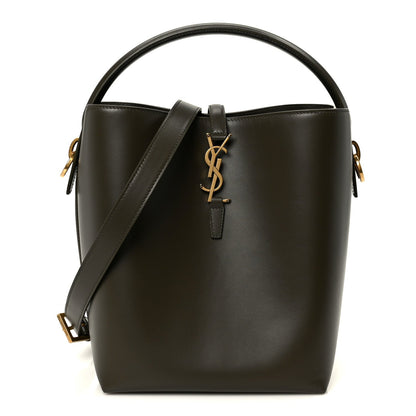 Shiny bucket bag with top handles, YSL charm detail, dark leather and gold hardware.