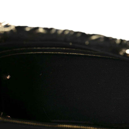 Close-up of black interior lining with gold chain detail along the edge