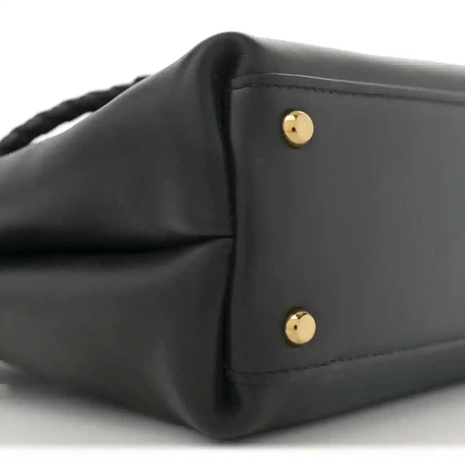 Black leather small shoulder bag with gold-tone snap buttons on front flap.