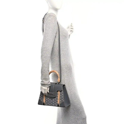Grey canvas top-handle bag with black leather flap, wood handle, worn crossbody strap