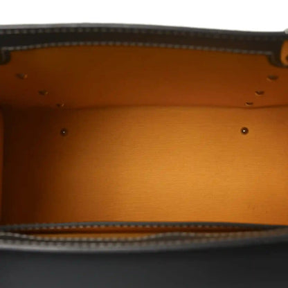 Tan fabric interior lining with stitched edge and metal rivets inside the bag