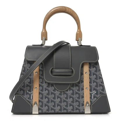 Grey canvas bag with black leather trim, top handles, and crossbody strap with wood accents