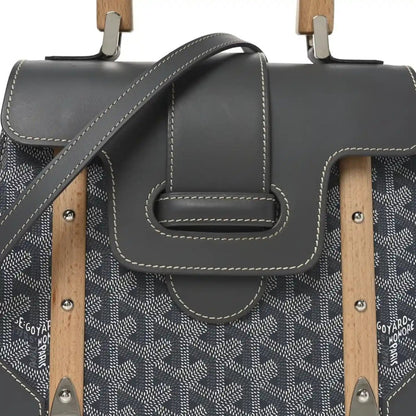 Grey canvas and black leather flap bag with wood handle mounts and stitched detail
