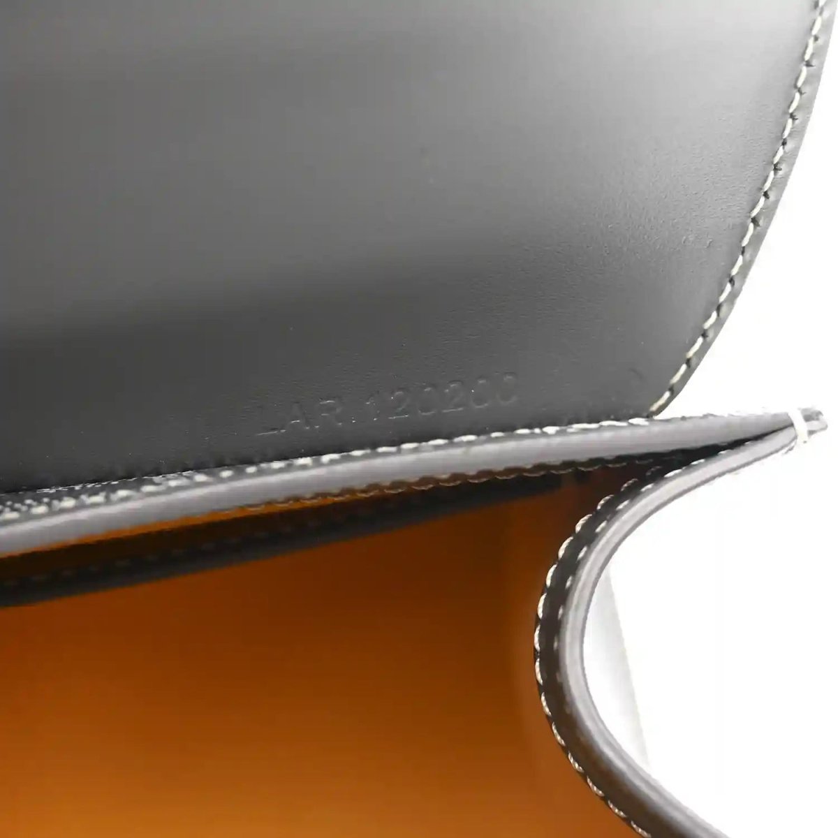 Grey leather mini Saigon bag close-up of interior marking and crossbody strap.