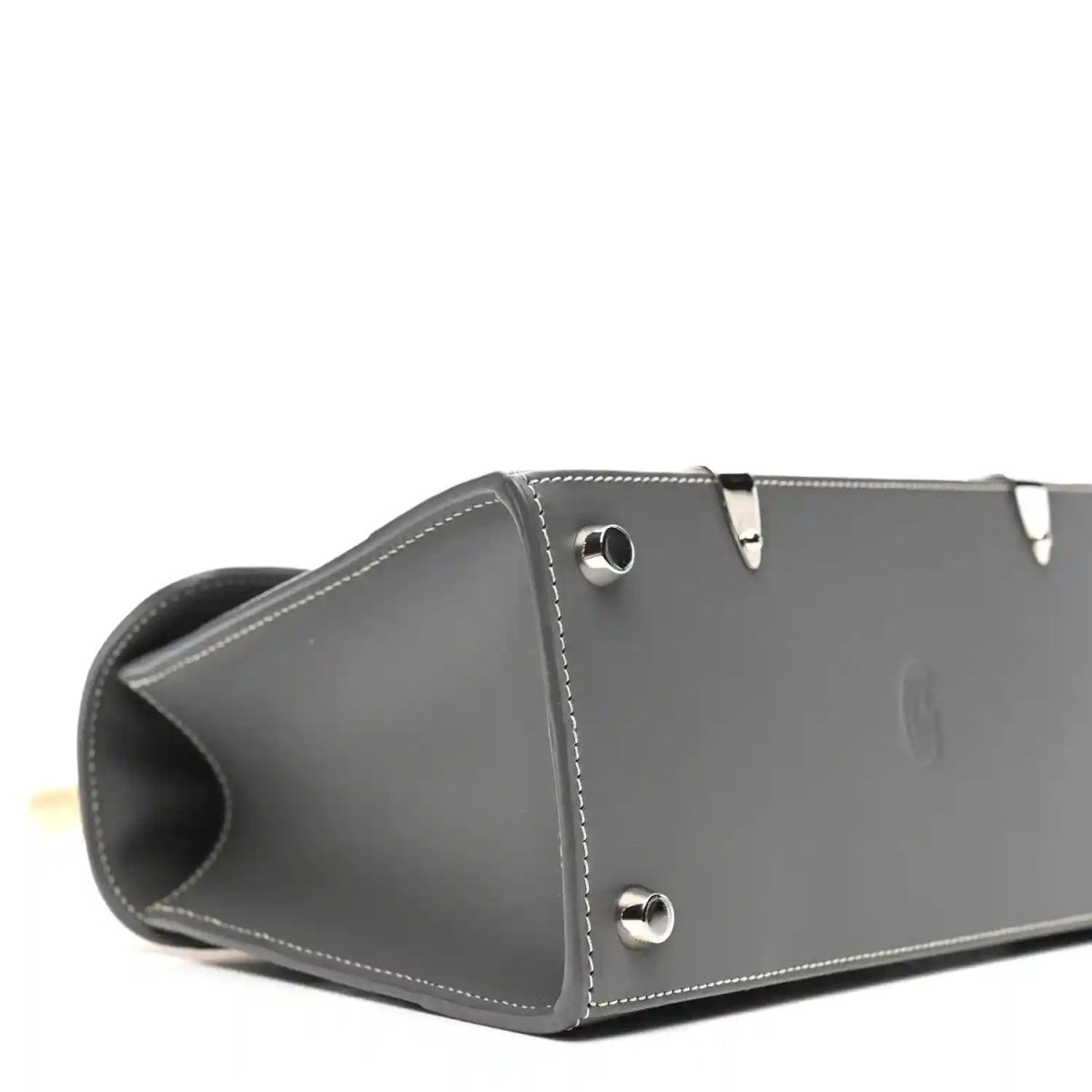 Grey leather mini Saigon bag side with metal snap studs and curved opening.