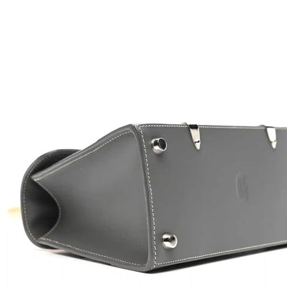 Grey leather mini Saigon bag side with metal snap studs and curved opening.