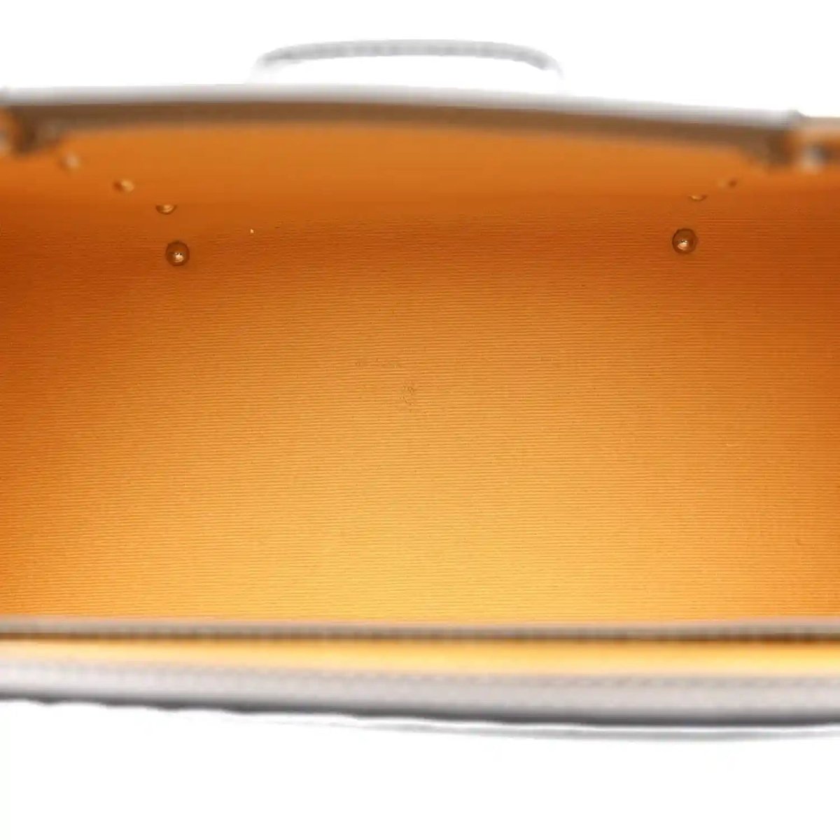 Orange fabric lining detail with metal rivets on grey mini Saigon bag.