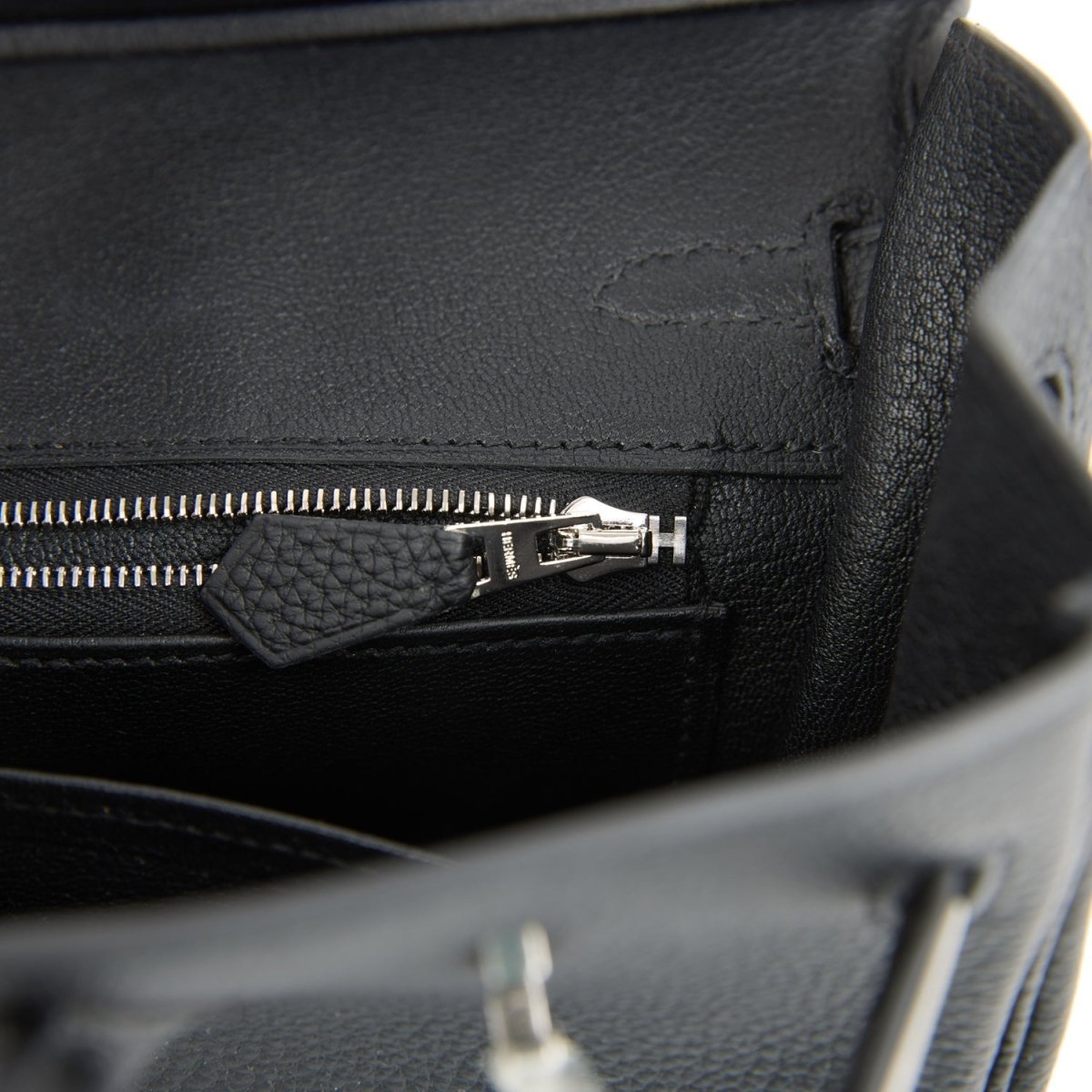 Black leather interior pocket with zipper and small metal pull detail.
