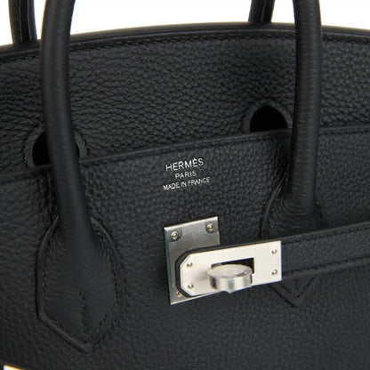 Black leather interior pocket with engraved brand plate and brushed palladium frame.