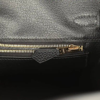 Black leather handbag interior with gold zipper and pull tab