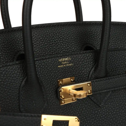 Black leather handbag with HERMÈS PARIS mark and gold turn-lock clasp