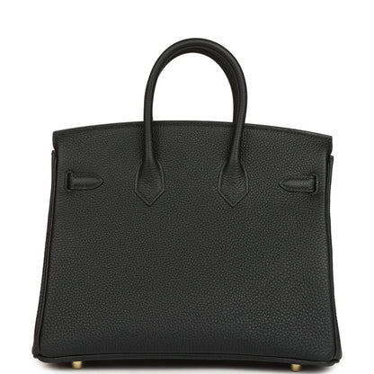 Black leather handbag back view with embossed panels and top handles