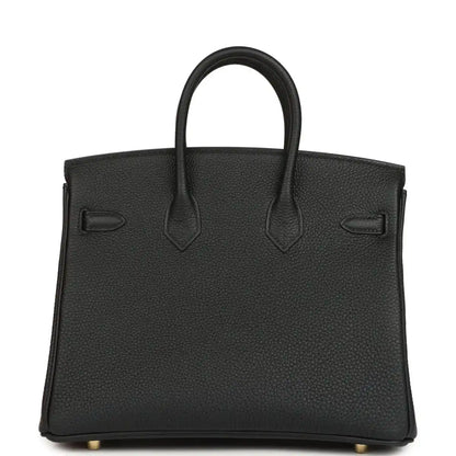 Black leather handbag back view with embossed panels and top handles