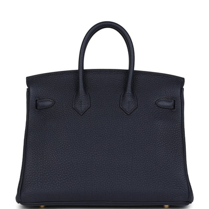 Hermes Birkin 25 handbag in dark blue leather with stitched panels and top handles.