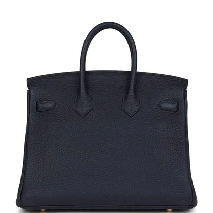 Hermes Birkin 25 handbag in dark blue leather with stitched panels and top handles.
