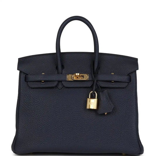 Hermes Birkin 25 handbag in dark blue Togo leather with gold hardware and top handles.
